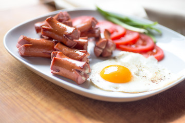 Grilled sausages and omlettr on white plate