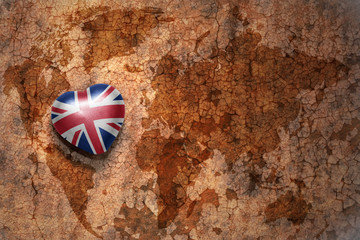 heart with national flag of great britain on a vintage world map crack paper background