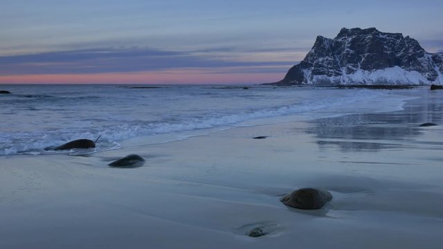 Waves at Utakliev beach in the Lofoten archipel in Norway during sunset at the end of a beautiful winter day.