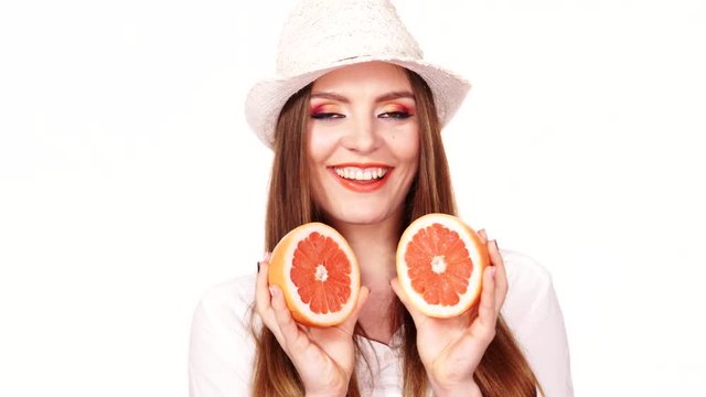 Woman holds two halfs of grapefruit citrus fruit in hands 4K