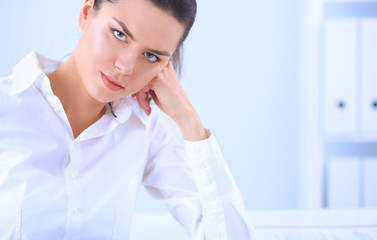 Attractive businesswoman sitting on a desk with laptop in the office