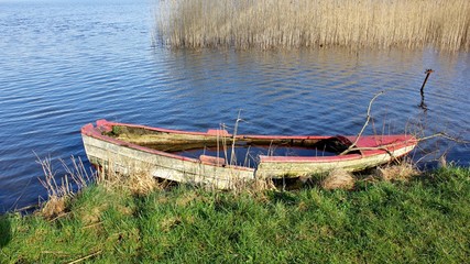 Fototapeta premium Abandoned, old boat at the lakeshore