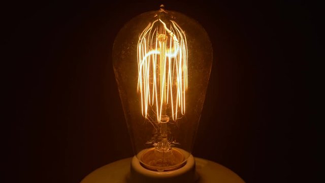 Vintage Light Bulb Turns On And Off In Socket With Filament Wire 4k