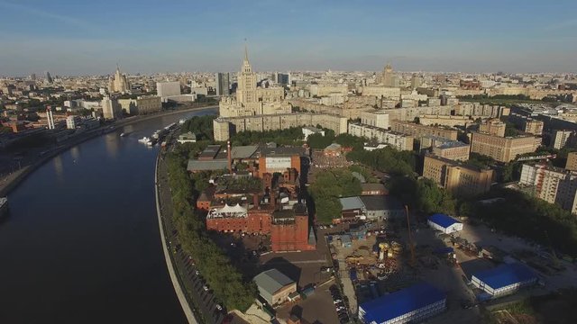 Quadrocopter fly over Moscow city in summer sunny evening. Modern and old edifices. Building of Radisson Royal Hotel. Moscow river