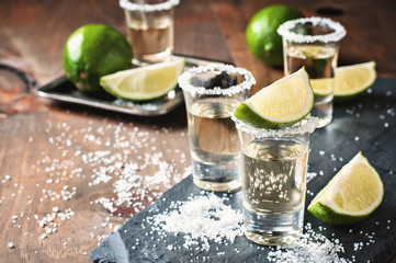 Tequila gold, Mexican, alcohol in shot glasses, lime and salt, toned image, selective focus