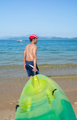 Man pulls a kayak to shore beach