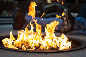 A couple relaxing by the outdoor fire in a ski village.