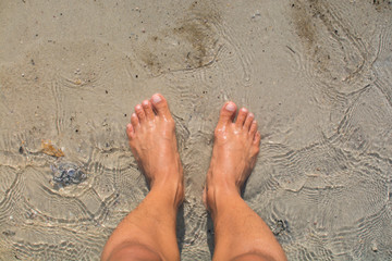 Standing barefoot on the beach top view