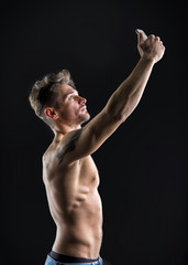 Fototapeta na wymiar Shirtless muscular young man using cell phone