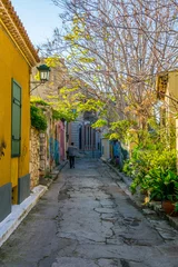 Selbstklebende Fototapeten View of a narrow street it plaka district of athens which is winding up to top of akropolis © dudlajzov
