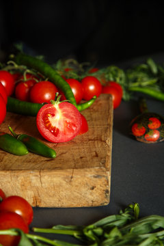 Tomatoes on wooden with green pappers and herbs