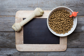 Dog bone and dog food on wood table