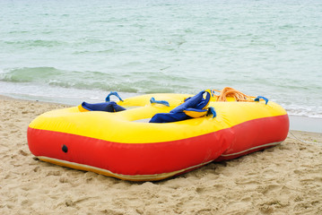 red yellow air mattress  at a beautiful beach with a sea