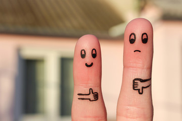 Finger art of couple. Woman showing thumbs up and man showing thumbs down. Concept of disagreement in family. - obrazy, fototapety, plakaty