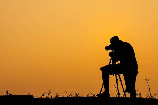 silhouette of photographer shooting photo for a sunrise