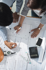 Team of architects examining blueprint of the house