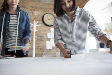 Two women are making the clothes of the pattern in the studio