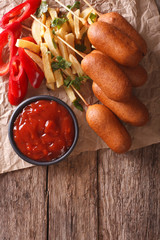 Corn dogs, french fries, pepper and ketchup. vertical top view
