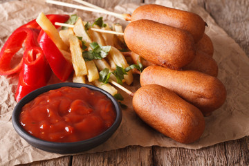 Corn dogs, french fries, pepper and ketchup close-up. horizontal
