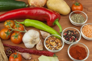 Spices and vegetables on wooden table. Preparing vegetable dishes. Diet food.
