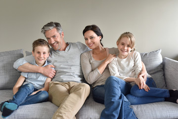 Portrait of happy family sitting in sofa