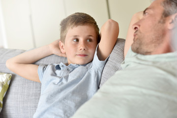 Fototapeta premium Daddy with son relaxing on sofa