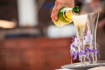 Waiter pours a glass of champagne at the wedding