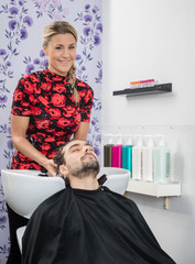 Beautician Washing Male Customer's Hair In Salon