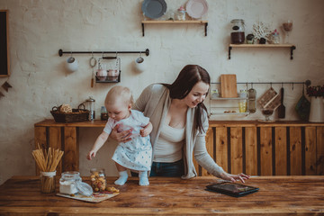 Mom and daughter playing together with tablet in home interior l