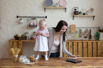 Mom and daughter have fun playing together with tablet in home i