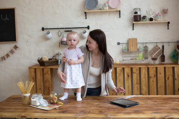 Mom and daughter have fun playing together with tablet in home i