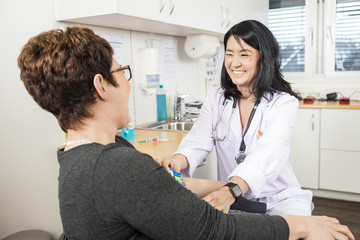 Doctor Adjusting Band On Patient's Hand