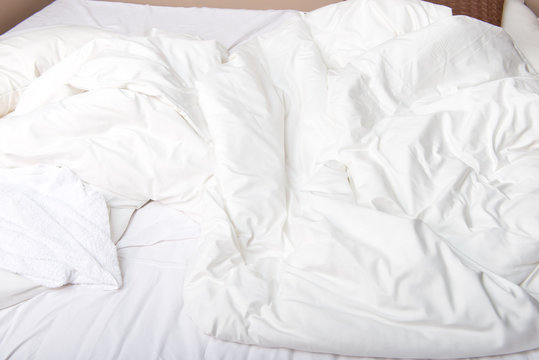 White bedcloth lying on bed
