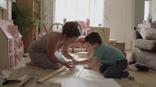 Mother And Son Assembling Flat Pack Draws. DIY