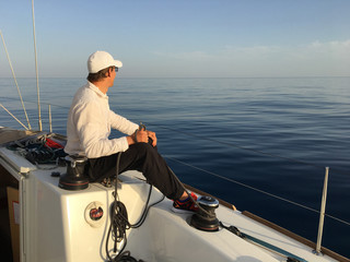 Young man sailing yacht yachtsman holding hands rope