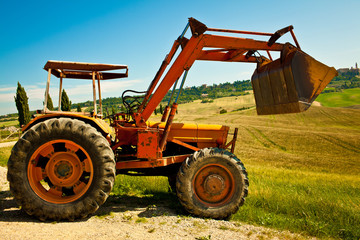 Red bulldozer in a what field in a sunny day