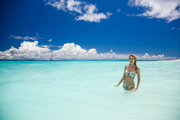 Slim blonde woman enjoys the turquoise ocean in Seychelles