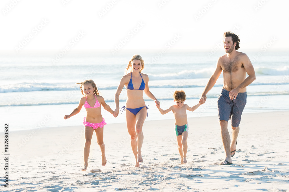 Wall mural Family running at beach