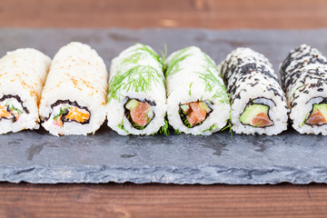 Homemade uramaki sushi rolls on a slate board