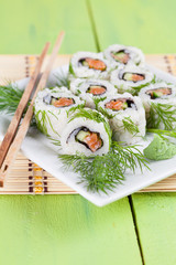 Uramaki sushi with cucumber, raw salmon and dill
