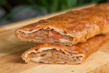 baking of unleavened dough stuffed with cabbage and dried apricots on a wooden board