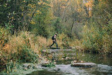 Fototapeta na wymiar Hunter enters the river