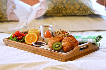 Breakfast tray in bed in hotel room
