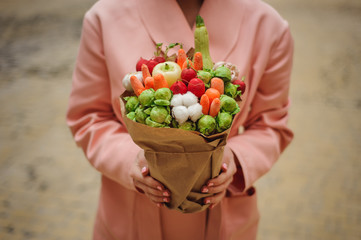 The original unusual edible vegetable and fruit bouquet  in woman hands