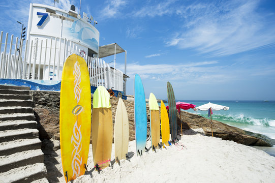 Colorful surfboards stand lined up on the beach at Arpoador in Rio de Janeiro, Brazil