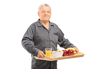 Mature man holding a tray with cereal
