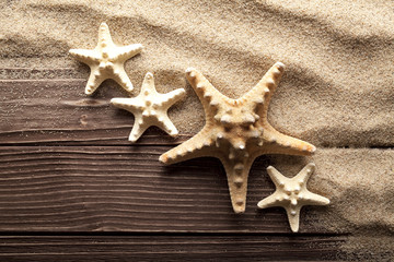 Starfishes on sand and wooden table