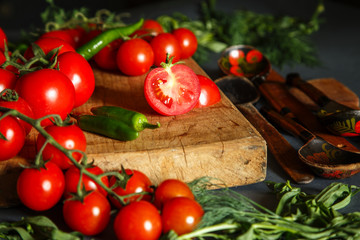 Tomatoes with green pappers and herbs on gray