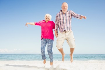 Happy senior couple jumping 