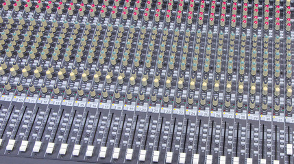 background of knobs and control buttons of a music mixer panel